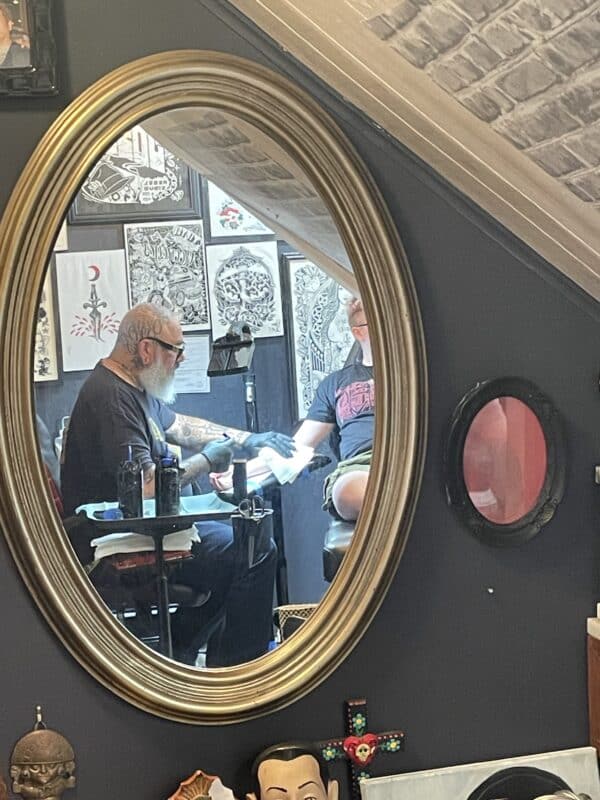 tattoo artist painless j works on a client