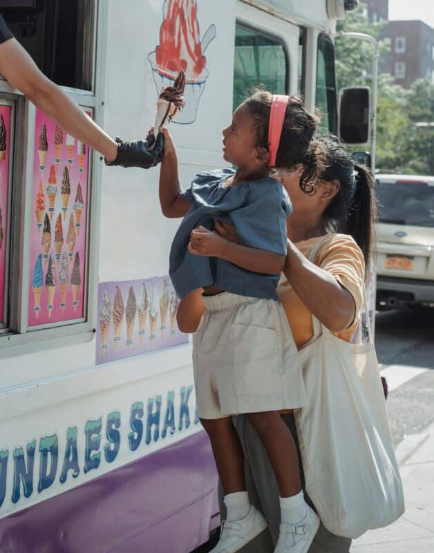 a child gets an ice cream truck from a food truck