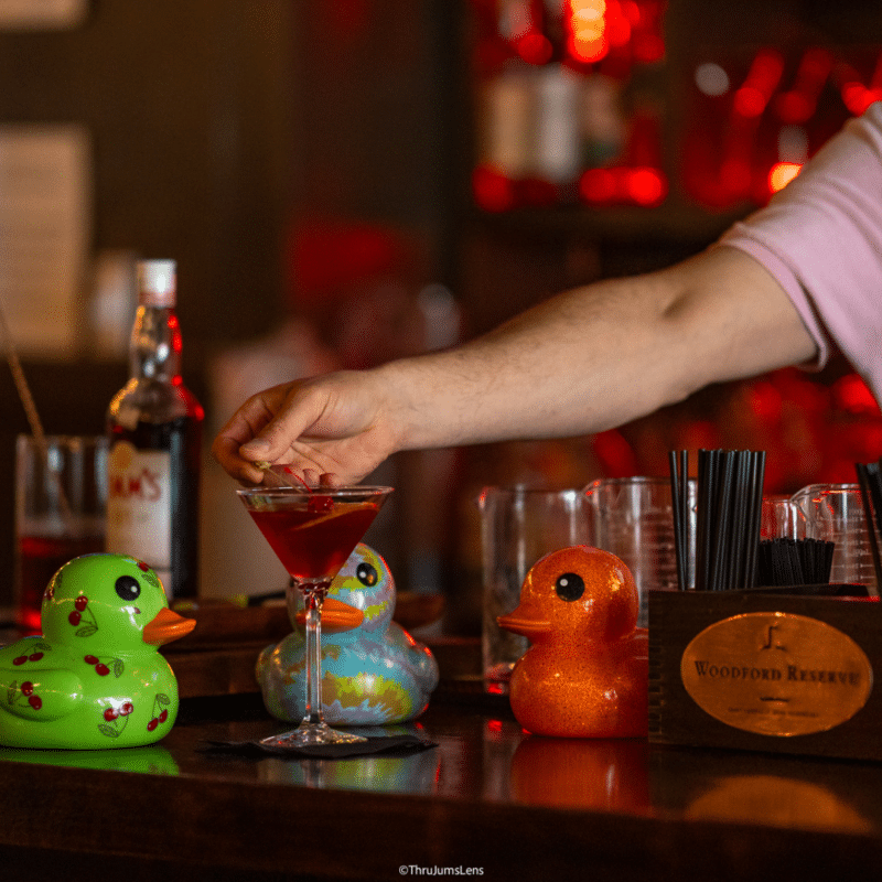 Josh serves a drink with the decorated rubber duckies in the foreground