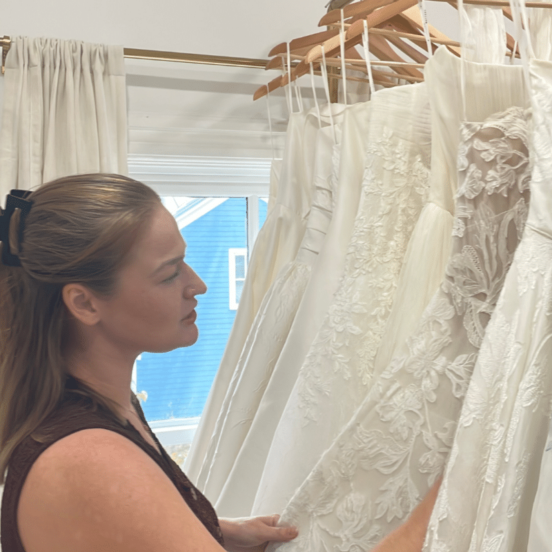 owner katie looks at gowns at clifton bridal