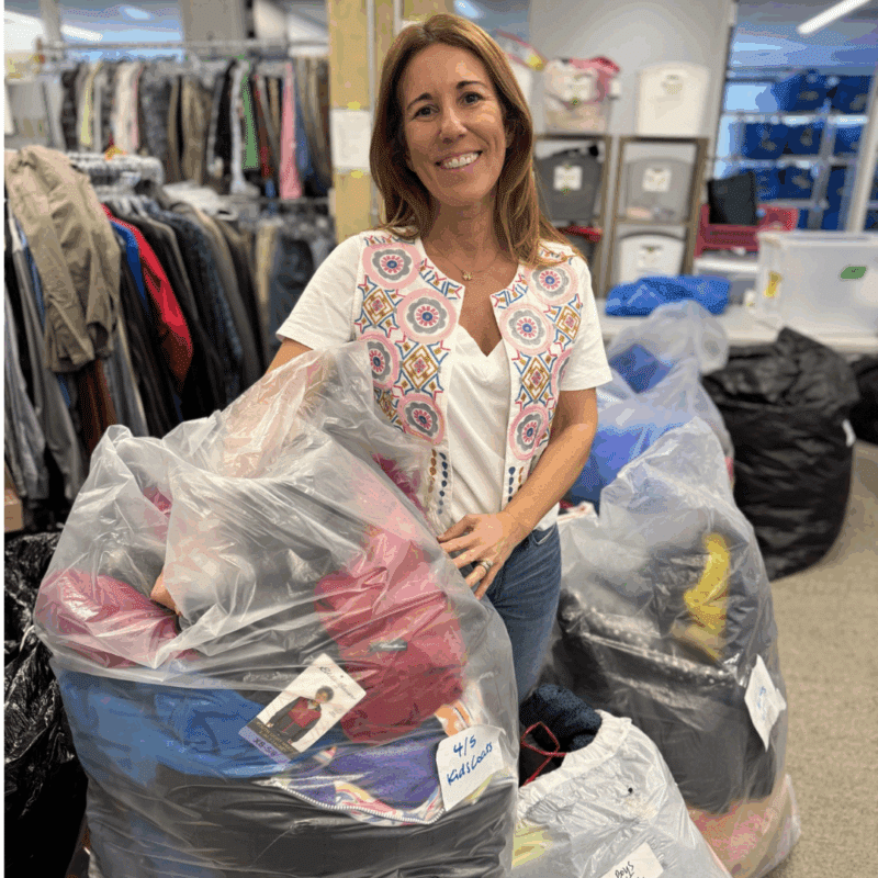 a volunteer at clothesline arlington shows off some donations